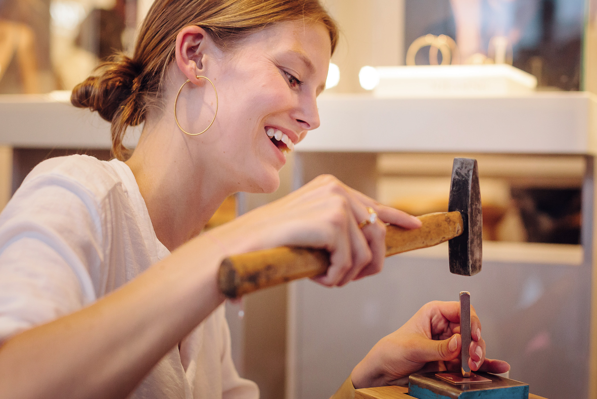 Blonde Frau die ein Kupferplättchen graviert