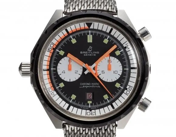 Die Breitling Superocean Chrono-Matic aus 1969 mit schwarzem Zifferblatt und orangenen Zeigern vor weißem Hintergrund