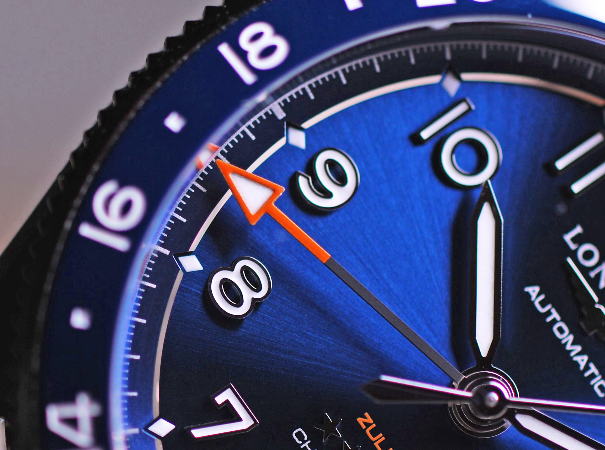 Detailaufnahme des blauen Zifferblattes und des orangefarbenen GMT-Zeigers der Longines Spirit Zulu Time 39