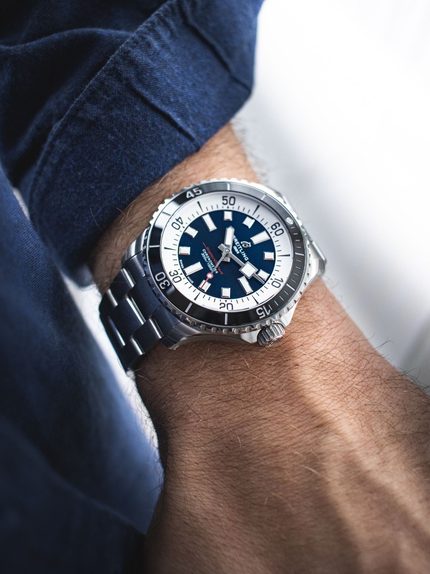 Breitling Superocean mit blauem Zifferblatt und schwarzer Lünette am Handgelenk