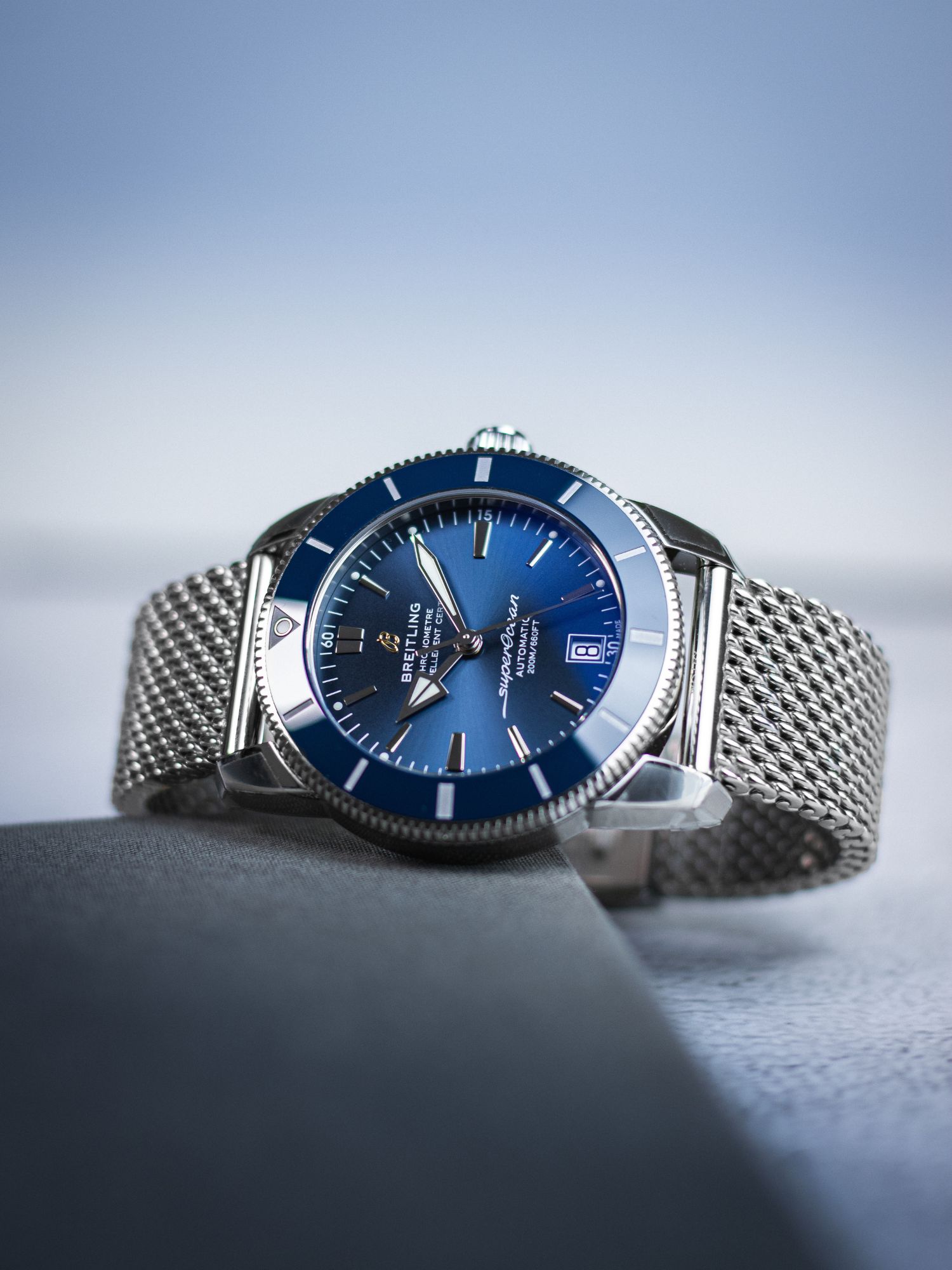 Breitling Superocean Heritage in blau liegend vor blauem Hintergrund