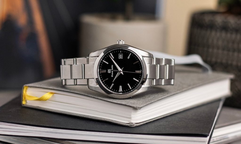 Grand Seiko Heritage Quarz Referenz SBGX261 mit schwarzem Zifferblatt am Edelstahlarmband auf der Seite auf Büchern liegend