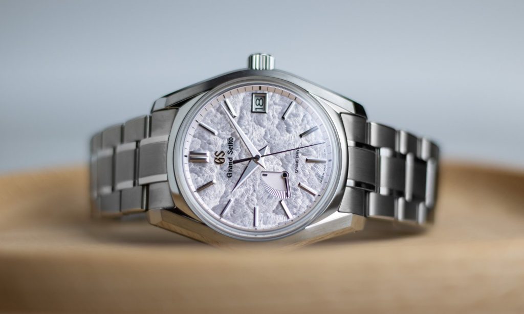 Grand Seiko Shunbun Referenz SBGA413 mit pinkem Zifferblatt am Edelstahlarmband auf der Seite liegend vor hellem Hintergrund