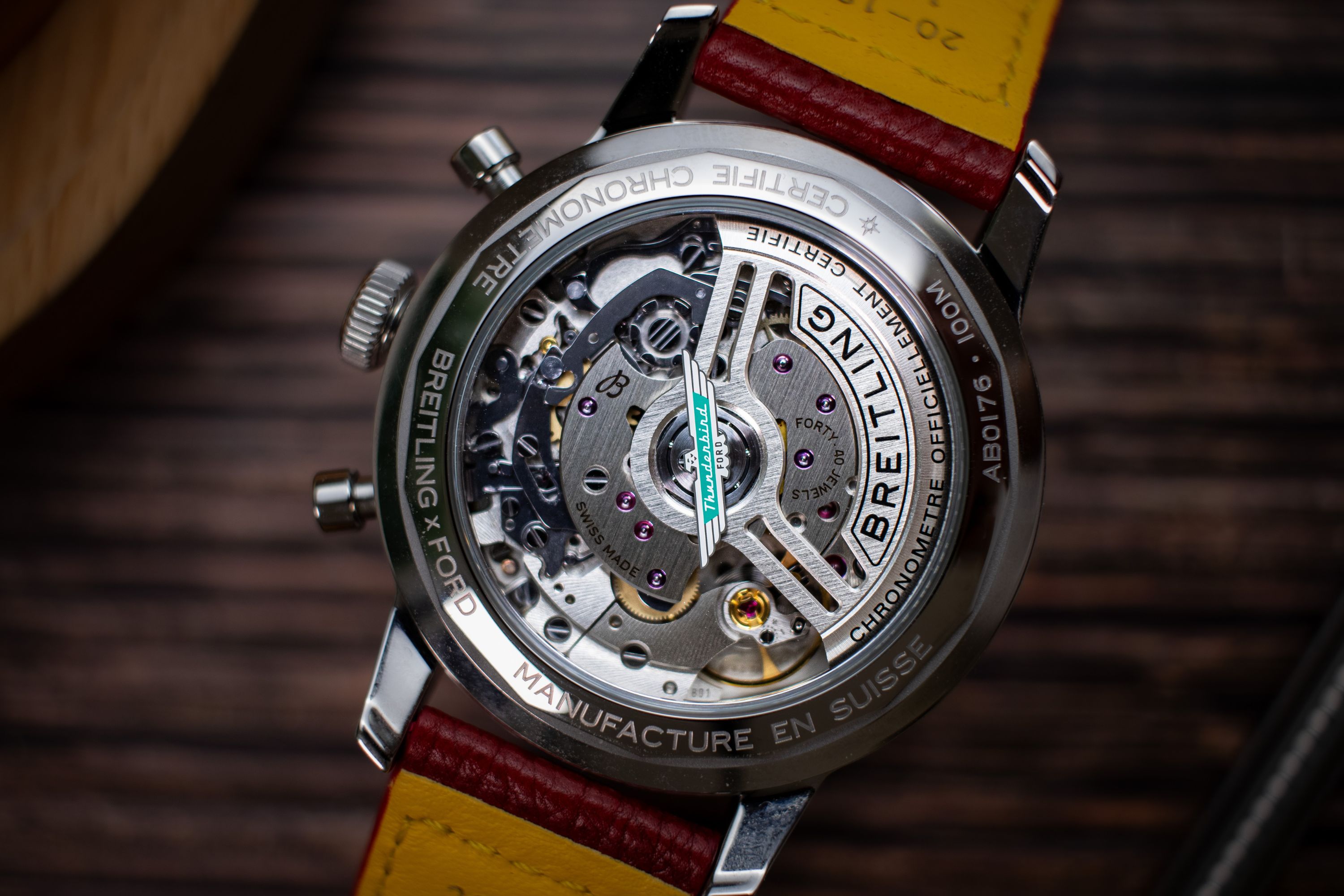 Nahaufnahme des Uhrwerks der Breitling Top Time Thunderbird in Weiß am roten Lederarmband