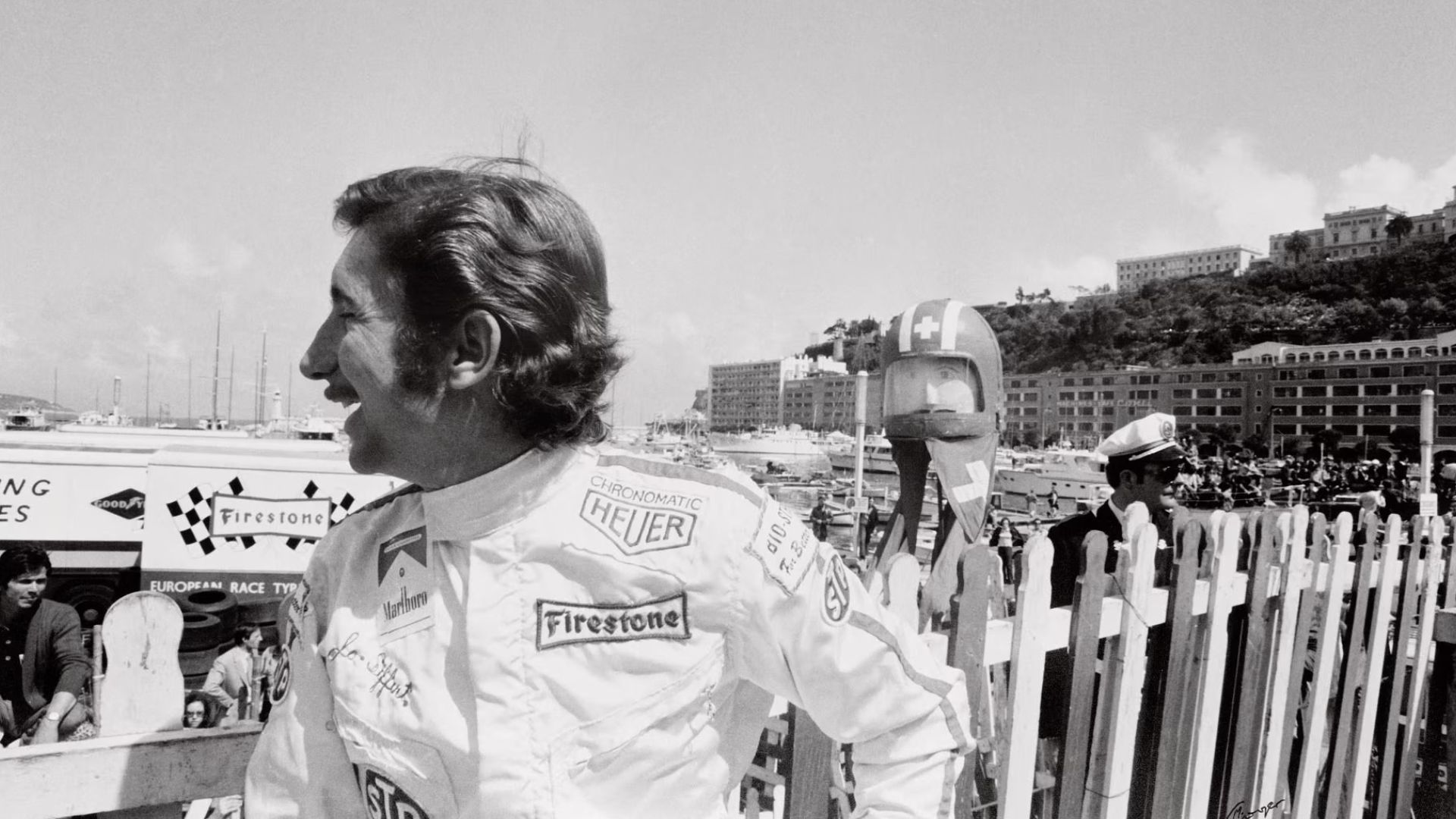 Der Rennfahrer Joseph Siffert im Rennanzug mit "Heuer"-Schriftzug