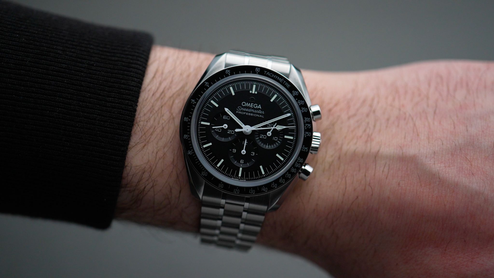 Wristshot der Omega Speedmaster Moonwatch Saphir am Stahlband