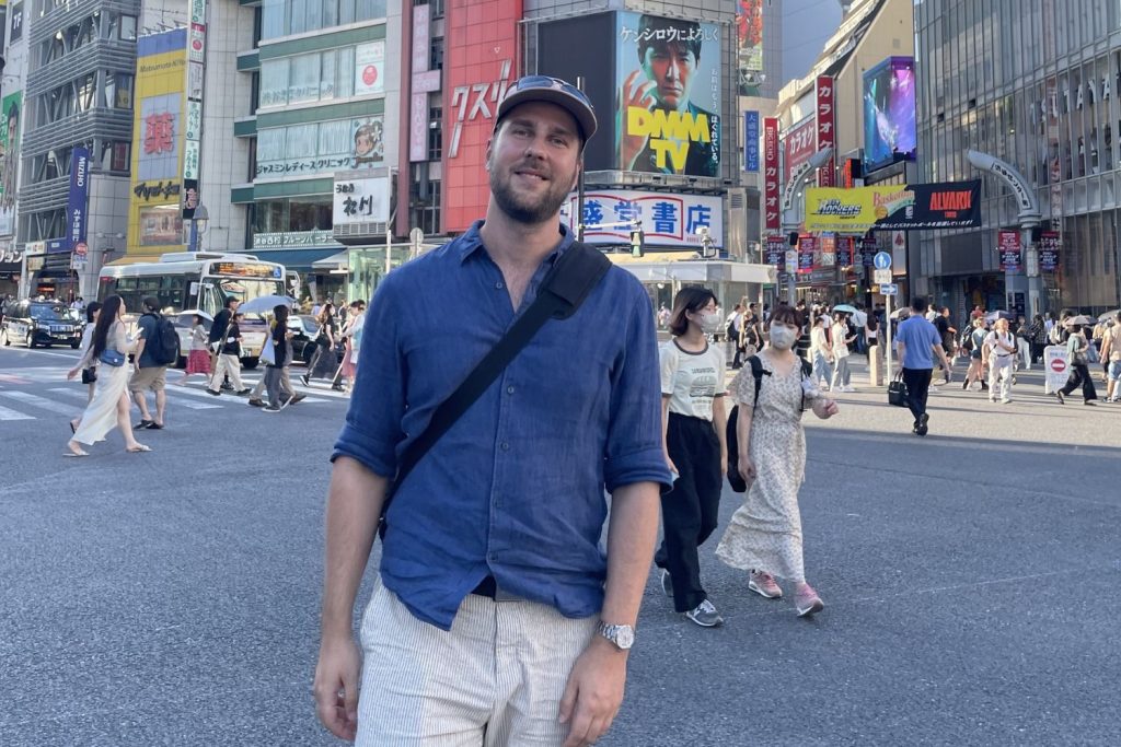 Thomas Dreblow mit einer Mütze auf dem Kopf und einer Grand Seiko am Handgelenk während seiner Japan-Reise vor dem Hintergrund des städtischen Treibens