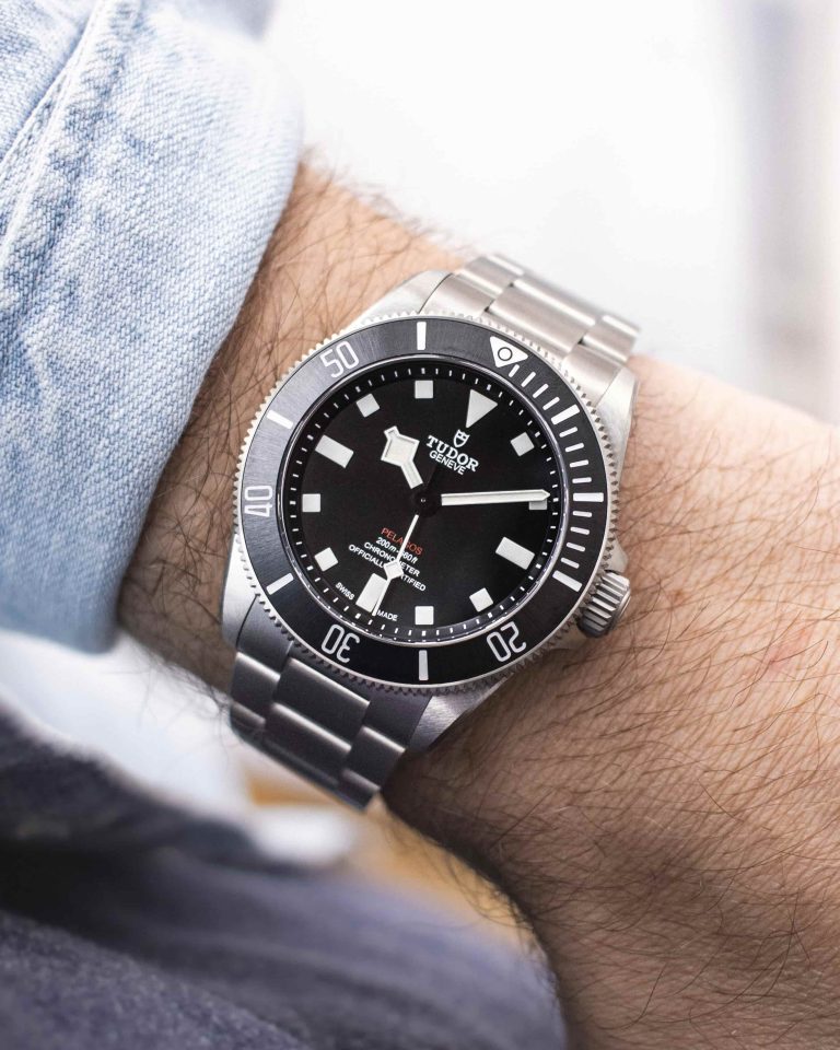 Tudor Pelagos 39 am Titanarmband abgebildet an einem Handgelenk mit hellblauem Ärmel vor hellem Hintergrund