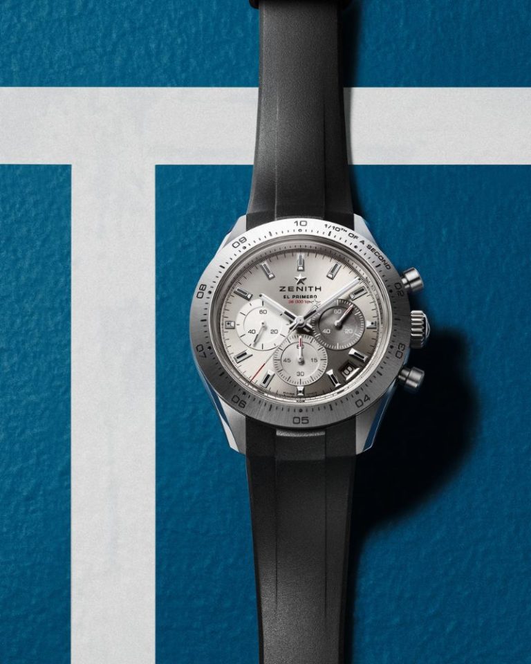 Zenith Chronomaster Sport Titanium am schwarzen Kautschukband liegend abgebildet vor weißblauem Hintergrund