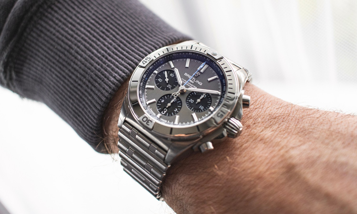 Breitling Chronomat Titan in 42 mm getragen im linken Handgelenk mit grauem Pullover