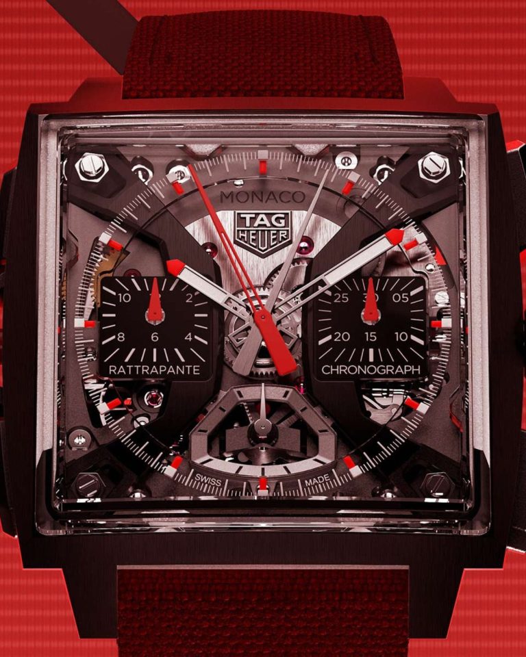TAG Heuer Monaco Split-Seconds Chronograph mit schwarzem Gehäuse, schwarzem Zifferblatt und rotem Armband vor rotem Hintergrund