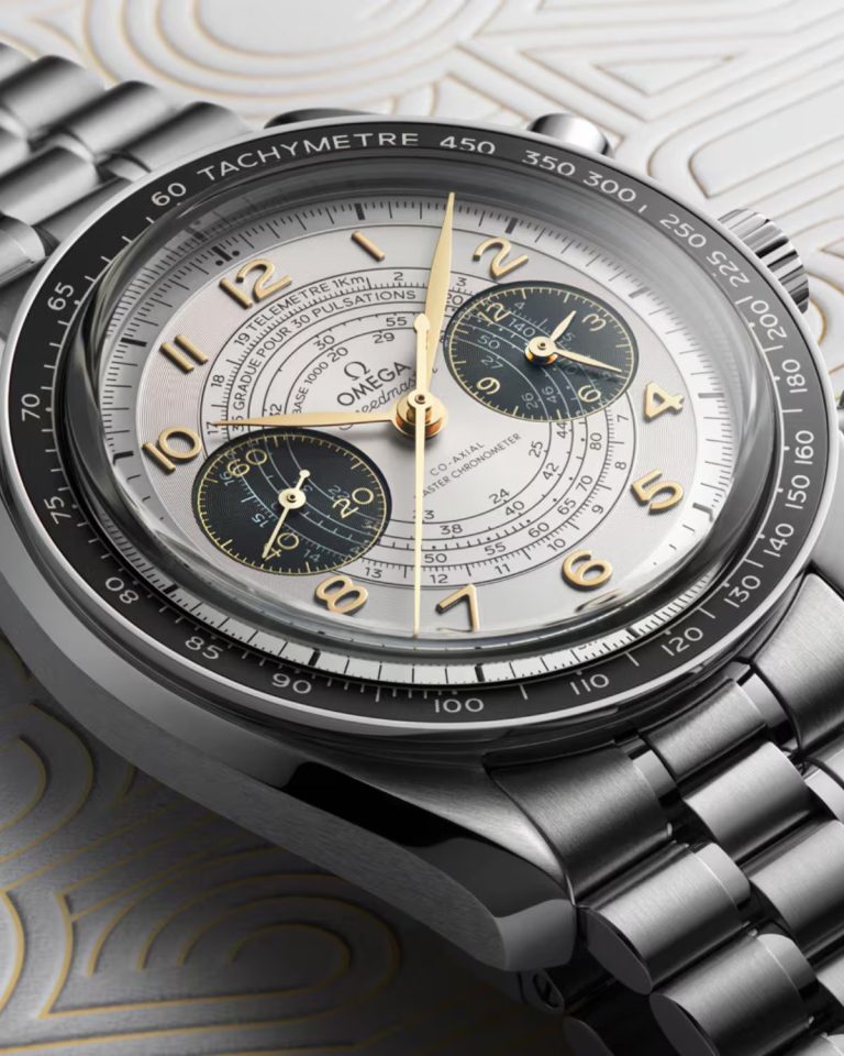 Nahaufnahme der neuen OMEGA Speedmaster Chronoscope Paris 2024 liegend vor grauem Hintergrund