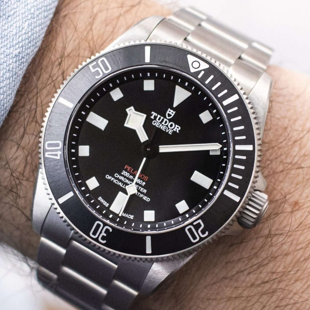 Tudor Pelagos 39 abgebildet an einem Handgelenk mit hellblauem Ärmel vor hellem Hintergrund