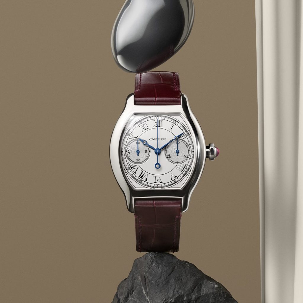 Die neue Cartier Tortue Monopoussoir an einem braunen Lederarmband vor braunem Hintergrund