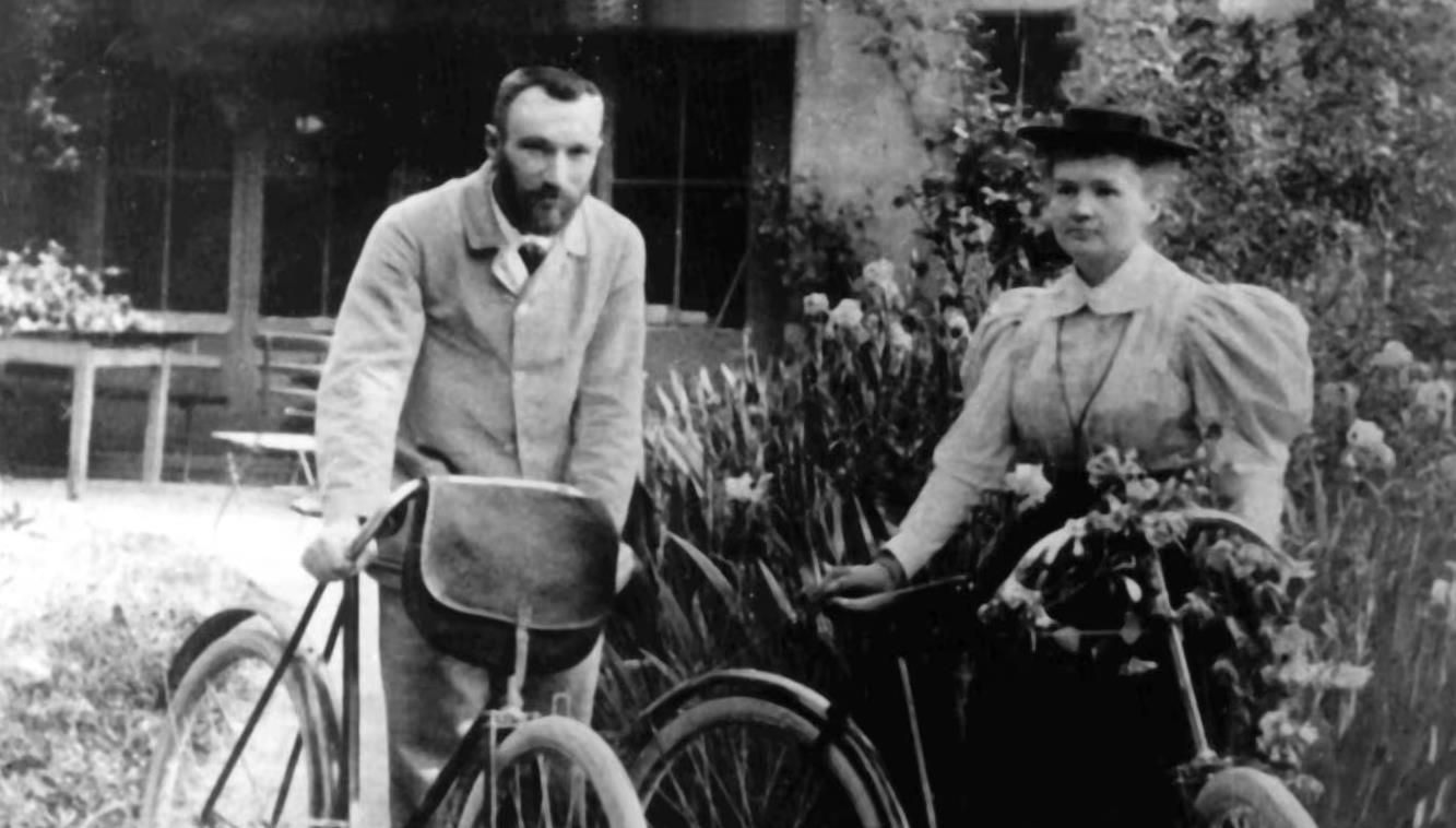 Pierre und Marie Curie mit ihren Fahrrädern.