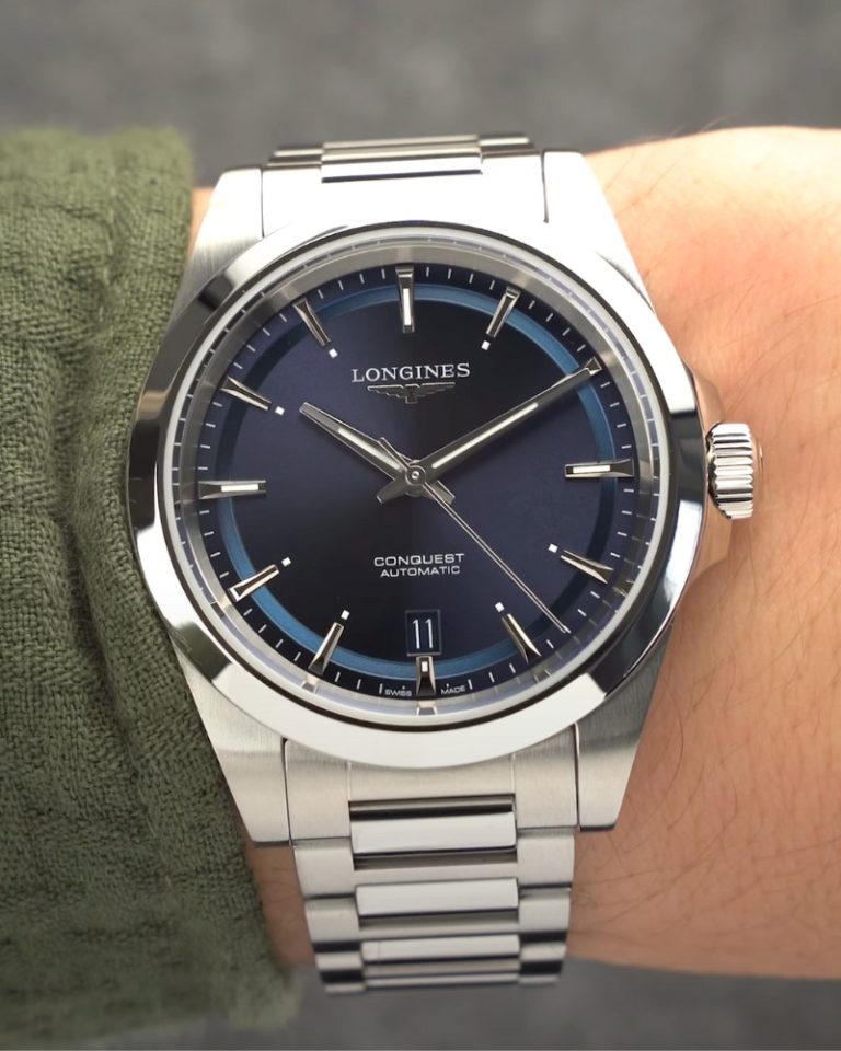 Nahaufnahme der Longines Conquest 38 mit blauem Zifferblatt am Edelstahlarmband an einem Handgelenk