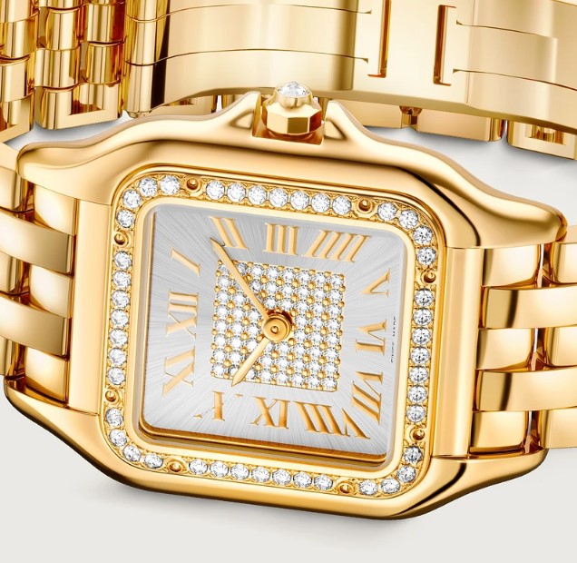 Cartier Panthère in gelbgold mit Diamantenbesatz auf Zifferblatt und Lünette liegend auf weißem Untergrund