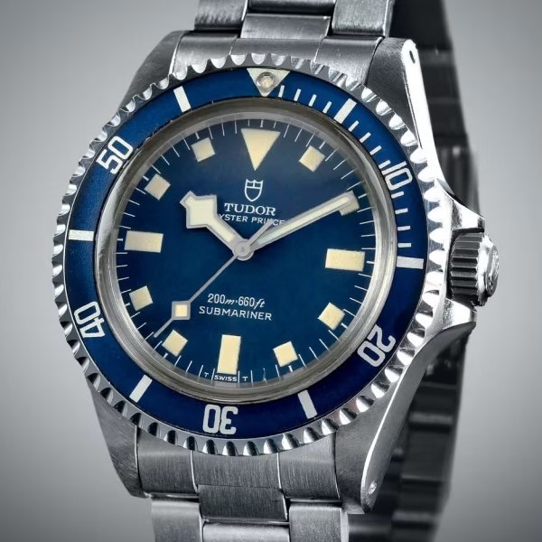 Tudor Submariner aus 1975 mit blauer Lünette und blauem Zifferblatt an einem Edelstahlarmband abgebildet vor grauem Hintergrund