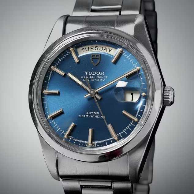 Tudor Oyster Prince Date Day aus 1969 mit blauem Zifferblatt und Edelstahlarmband abgebildet vor grauem Hintergrund