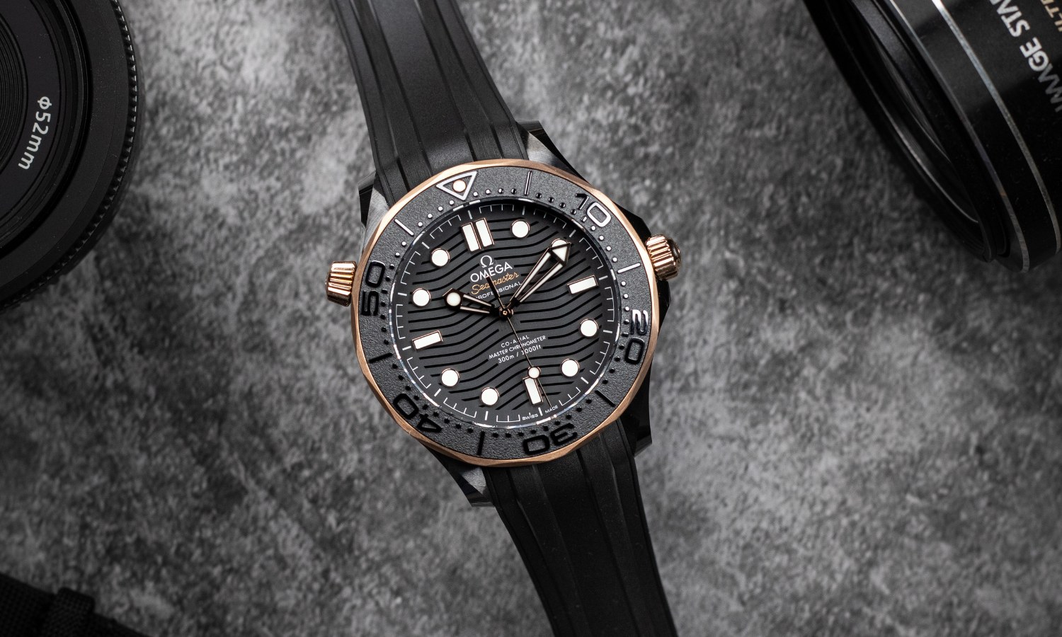 OMEGA Seamaster Diver 300M Sedna Gold liegend von vorne vor dunkelgrauem Hintergrund