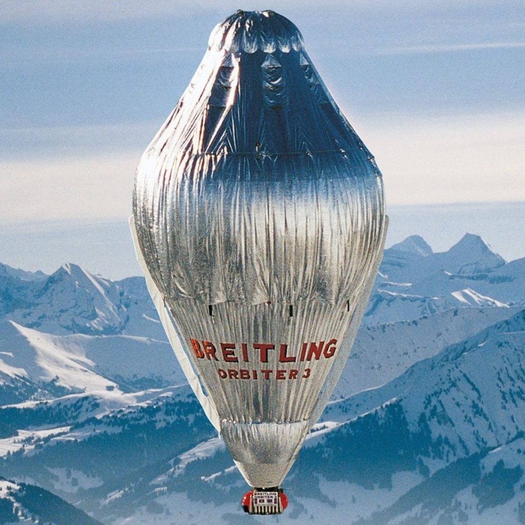 Ansicht des Ballons Breitling Orbiter 3 als er gerade über verschneite Berge fährt.