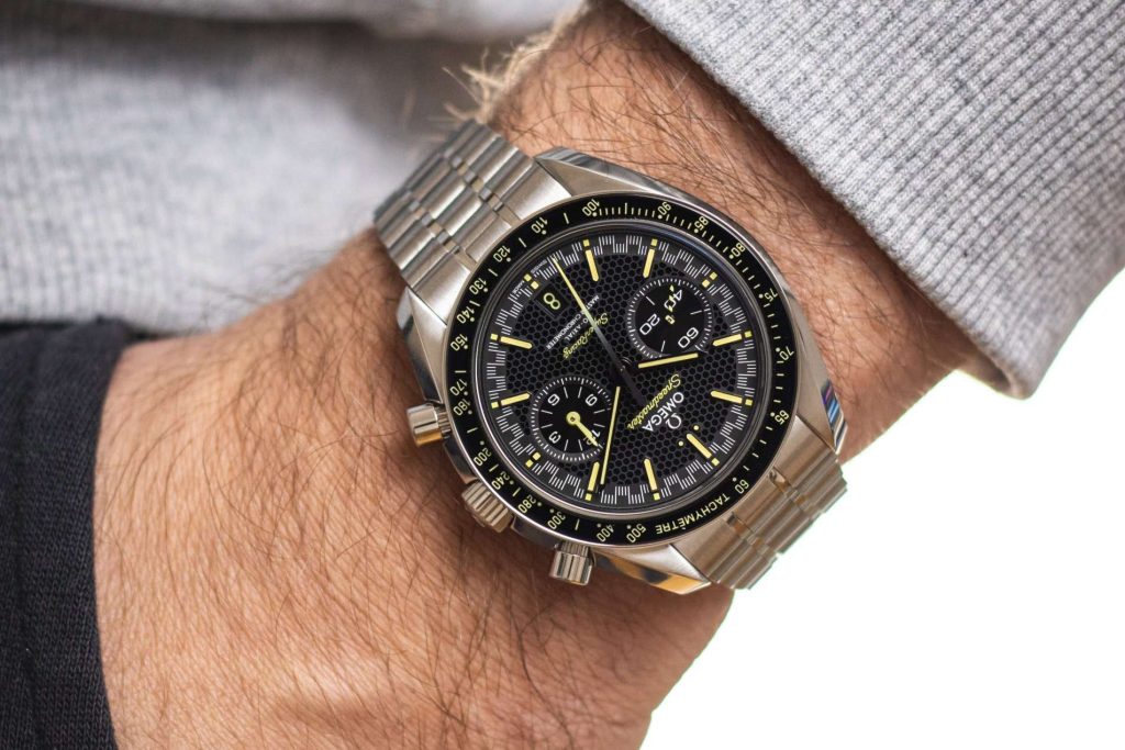 Omega Speedmaster Super Racing abgebildet an einem Handgelenk mit grauem Ärmel vor weißem Hintergrund