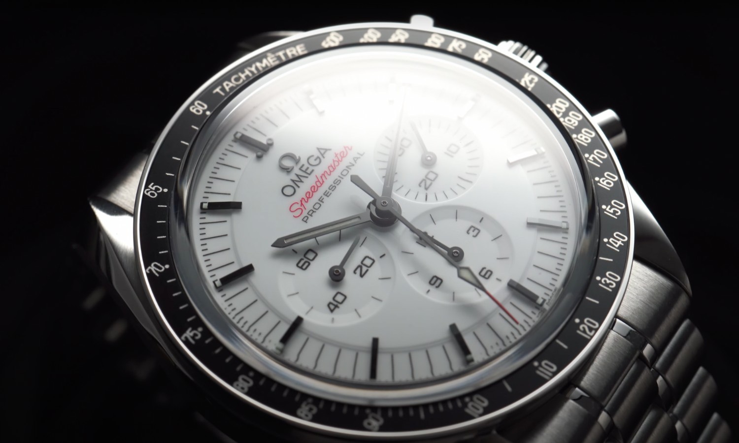 Nahaufnahme des Zifferblatts der OMEGA Speedmaster Professional Moonwatch vor schwarzem Hintergrund