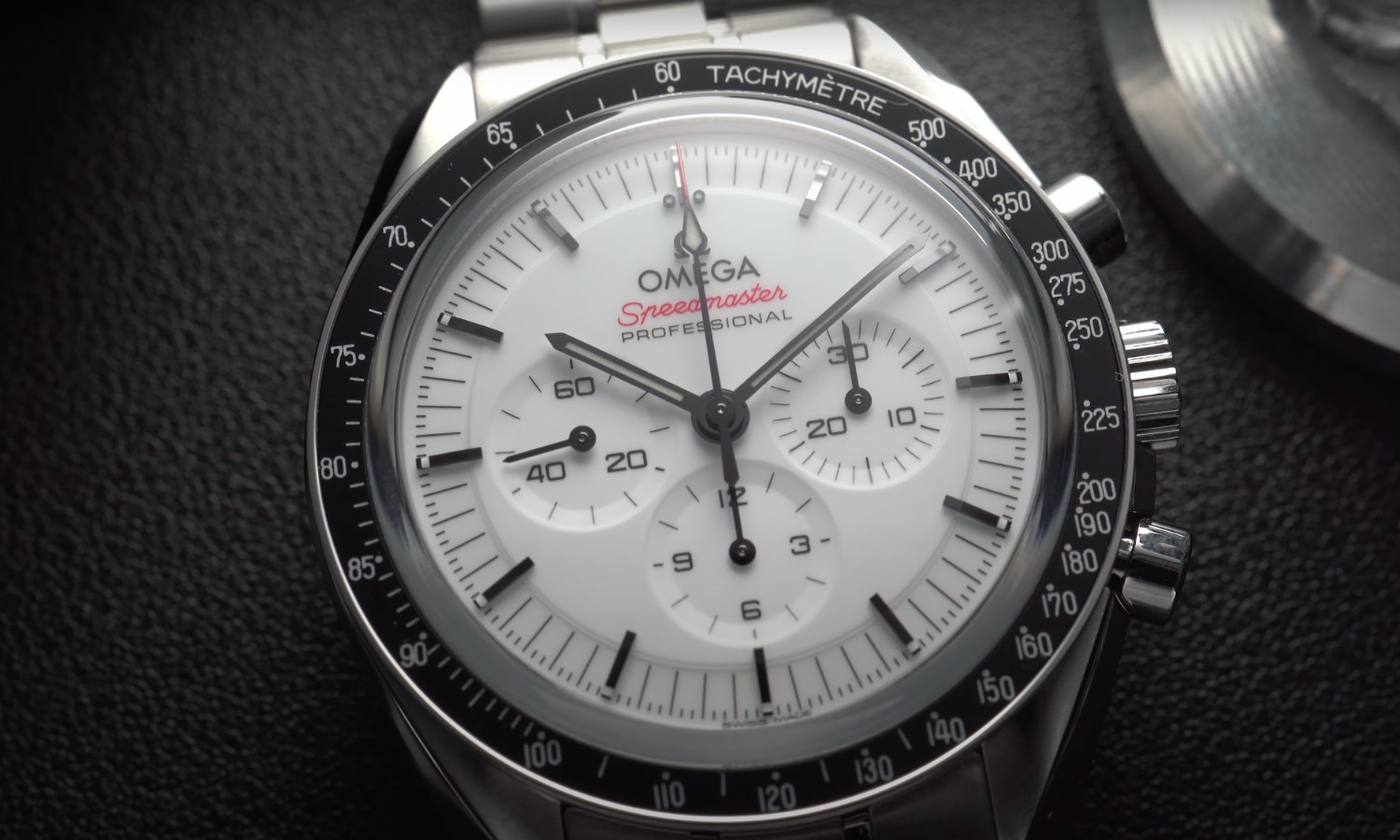 Nahaufnahme des Zifferblatts der OMEGA Speedmaster Professional Moonwatch vor schwarzem Hintergrund