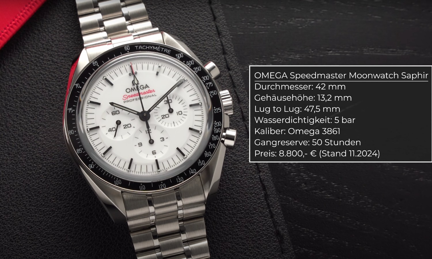 Die OMEGA Speedmaster Professional Moonwatch mit weißem Zifferblatt am Edelstahlarmband liegend vor schwarzem Hintergrund