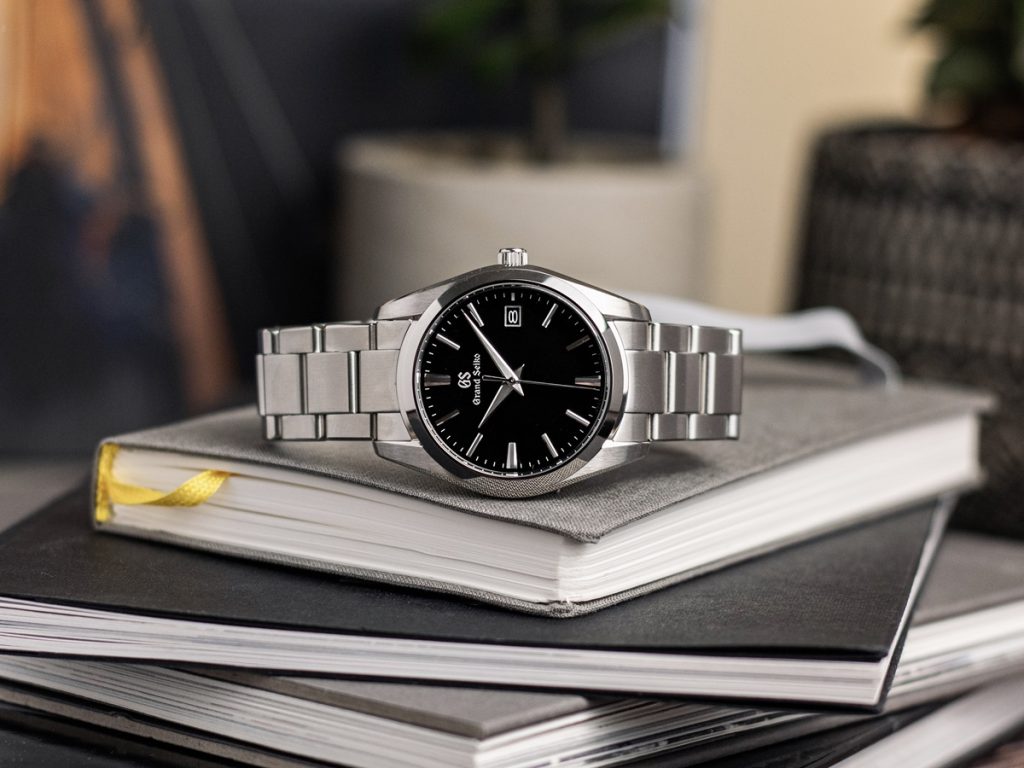 Blick auf die Grand Seiko SBGX261, die auf einem Stapel von Büchern liegt.