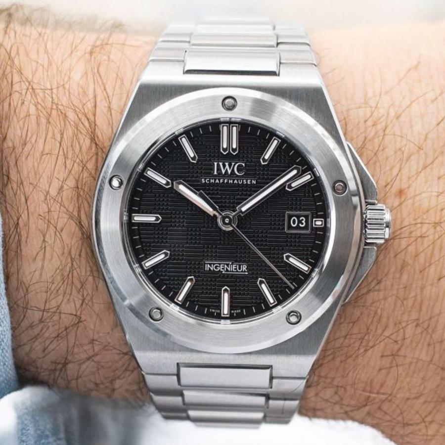 Nahaufnahme der IWC Ingenieur mit schwarzem Zifferblatt auf dem Handgelenk eines Mannes.