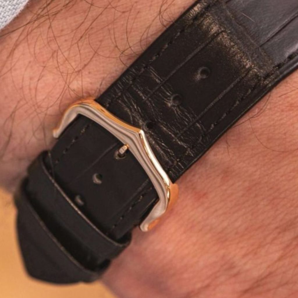 Blick auf das Lederband der Cartier Tank Louis Jumbo auf dem Handgelenk eines Mannes.
