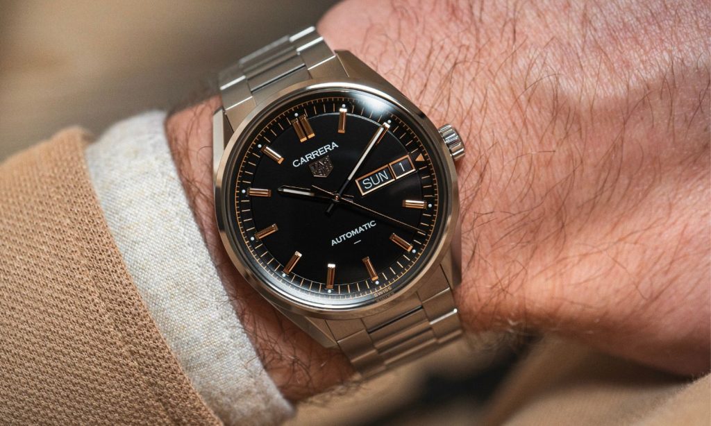 Blick auf die schwarze Variante der neuen TAG Heuer Carrera Day-Date auf dem Handgelenk eines Mannes.