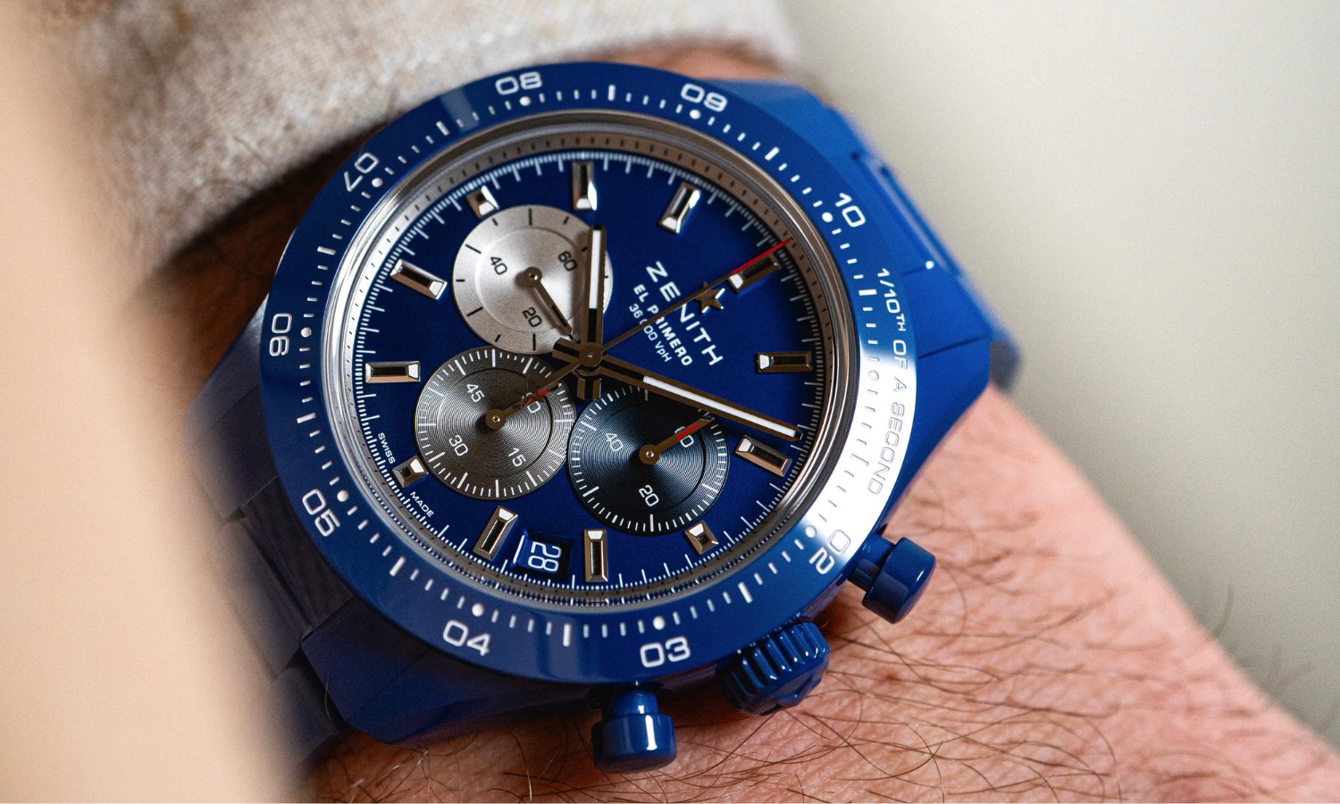 Zenith Chronomaster Sport blaue Keramik mit blauem Zifferblatt am blauen Keramikarmband an einem Handgelenk mit beigem Ärmel getragen
