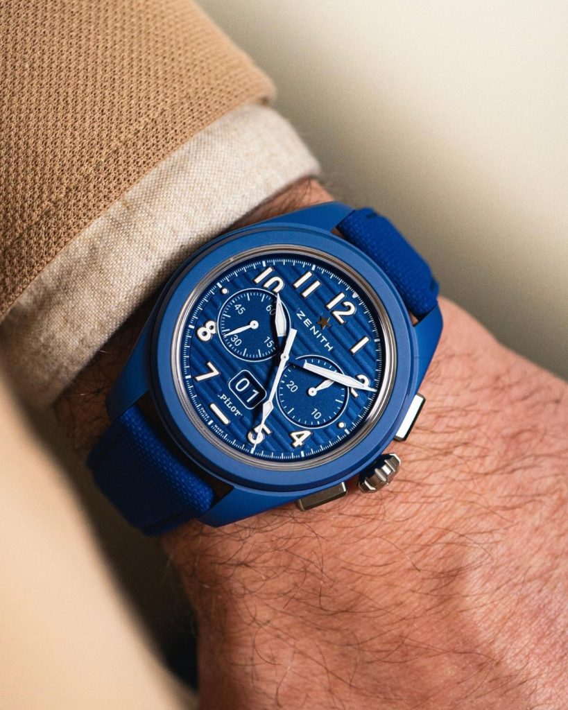Zenith Pilot Flyback blaue Keramik mit blauem Zifferblatt am blauen Keramikarmband an einem Handgelenk mit beigem Ärmel getragen