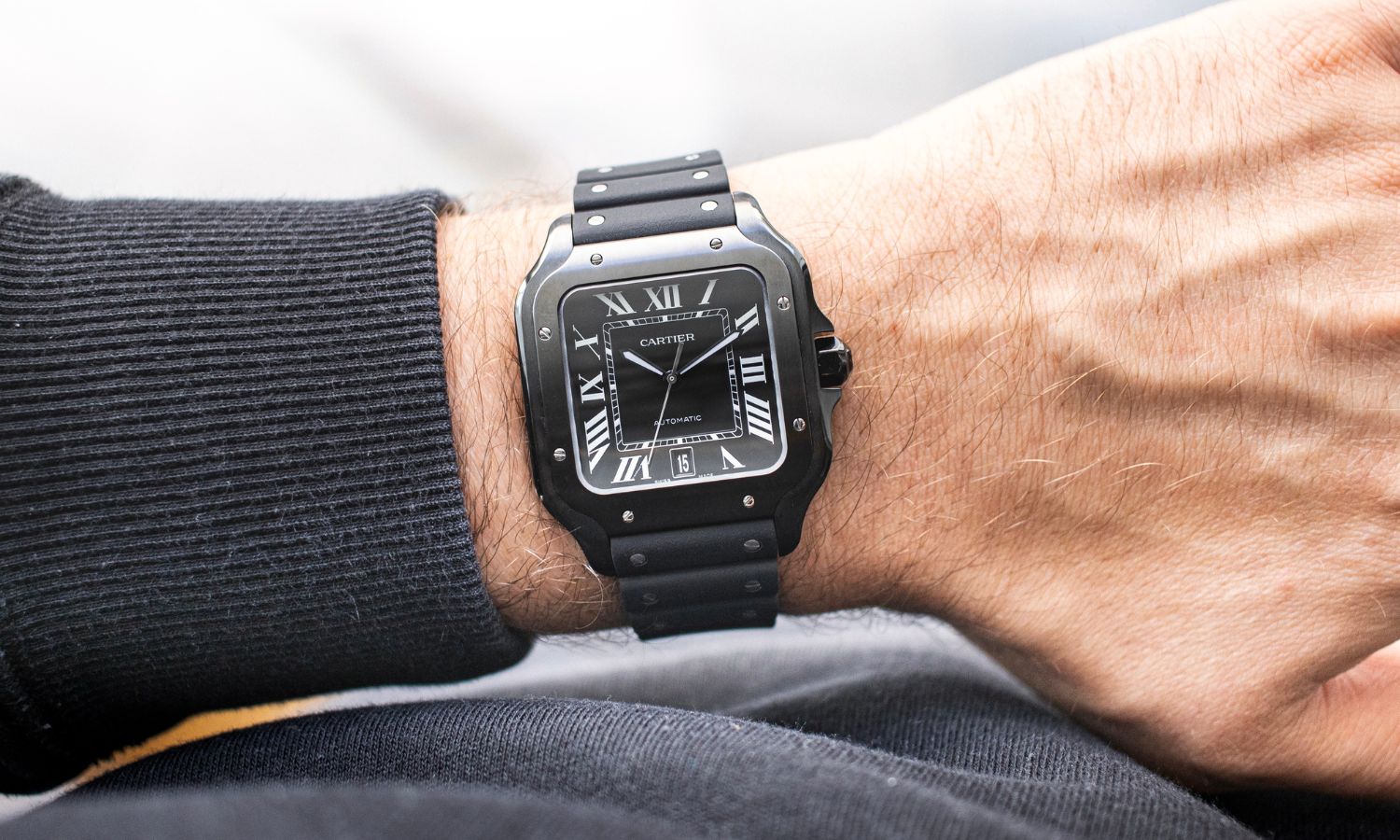 Blick auf die Cartier Santos de Cartier mit der Referenz WSSA0039 auf dem Handgelenk eines Mannes.