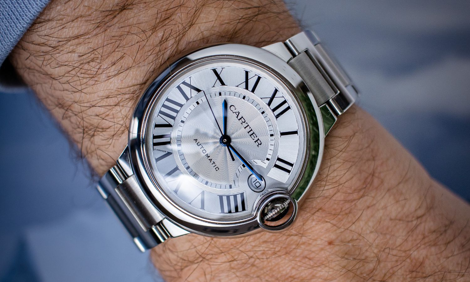 Seitlicher Blick auf die Cartier Ballon Bleu WSBB0040 auf dem Handgelenk eines Mannes.