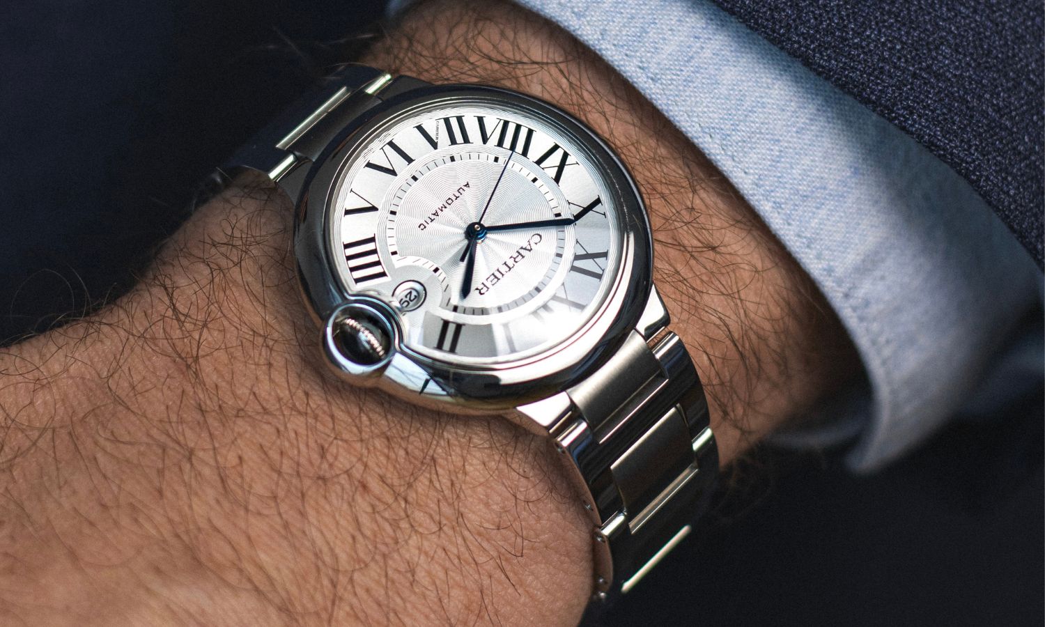 Seitlicher Blick auf die Cartier Ballon Blue mit der Referenz WSBB0040 auf dem Handgelenk eines Mannes.