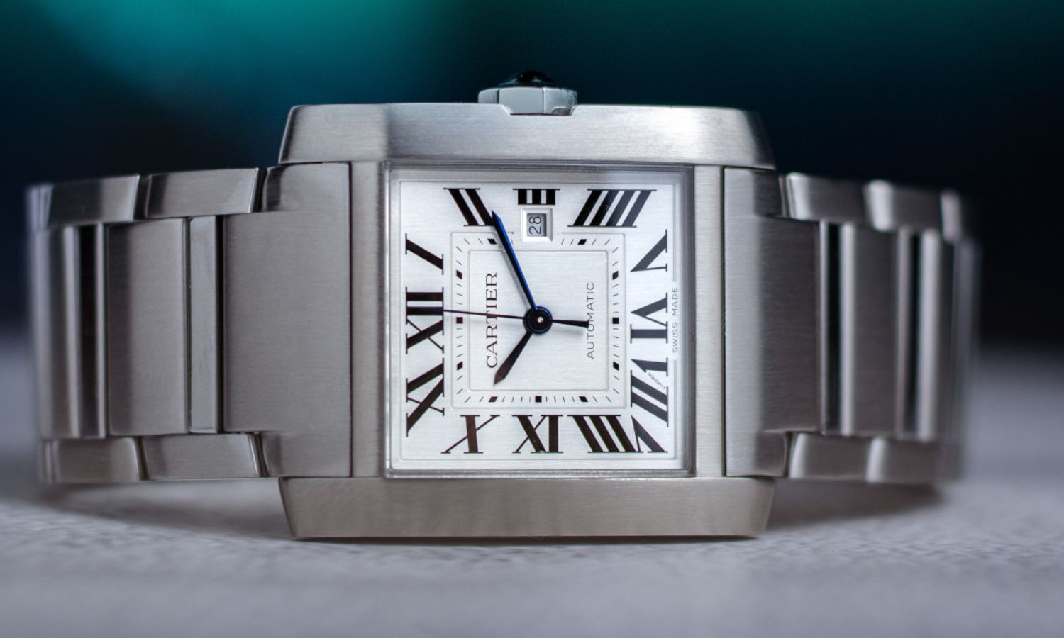 Seitlicher Blick auf die Cartier Tank Française mit der Referenz WSTA0067 auf einem Tisch.