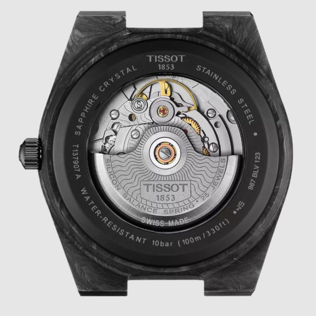 Nahaufnahme des offenen Gehäusebodens der Tissot PRX Powermatic 80 Carbon vor weißem Hintergrund