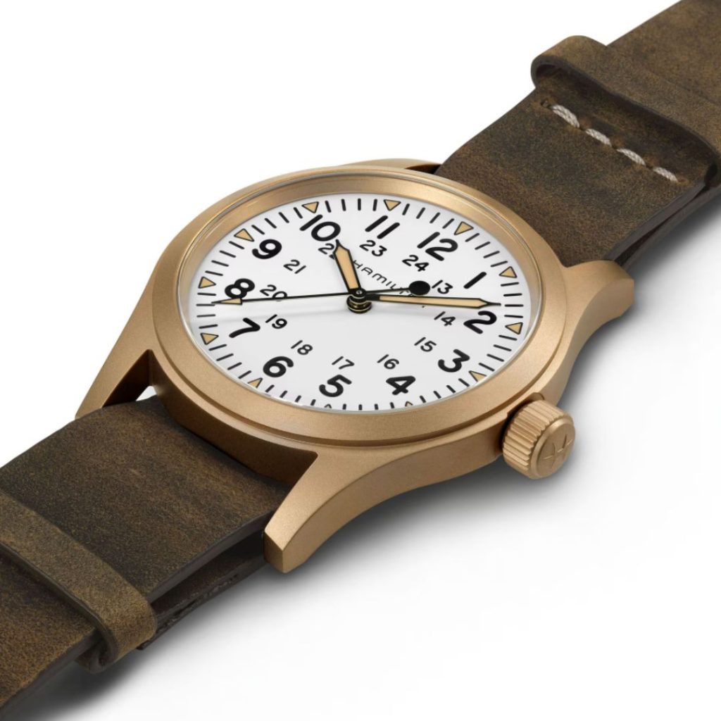 Seitliche Aufnahme der Hamilton Khaki Field Mechanical Bronze mit weißem Zifferblatt und braunem Lederarmband vor weißem Hintergrund