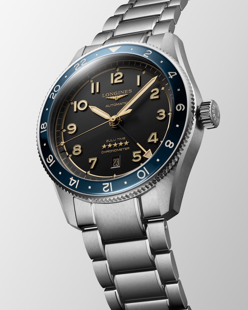Longines Spirit Zulu Time mit blaue Keramiklünette vor grauem Hintergrund