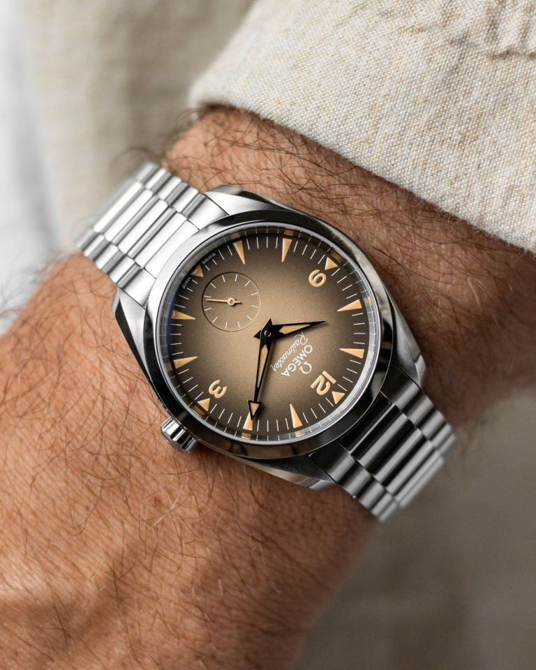 OMEGA Seamaster Railmaster Referenz: 235.10.38.20.13.001 mit beigem Zifferblatt am Edelstahlarmband an einem Handgelenk mit beigem Ärmel getragen