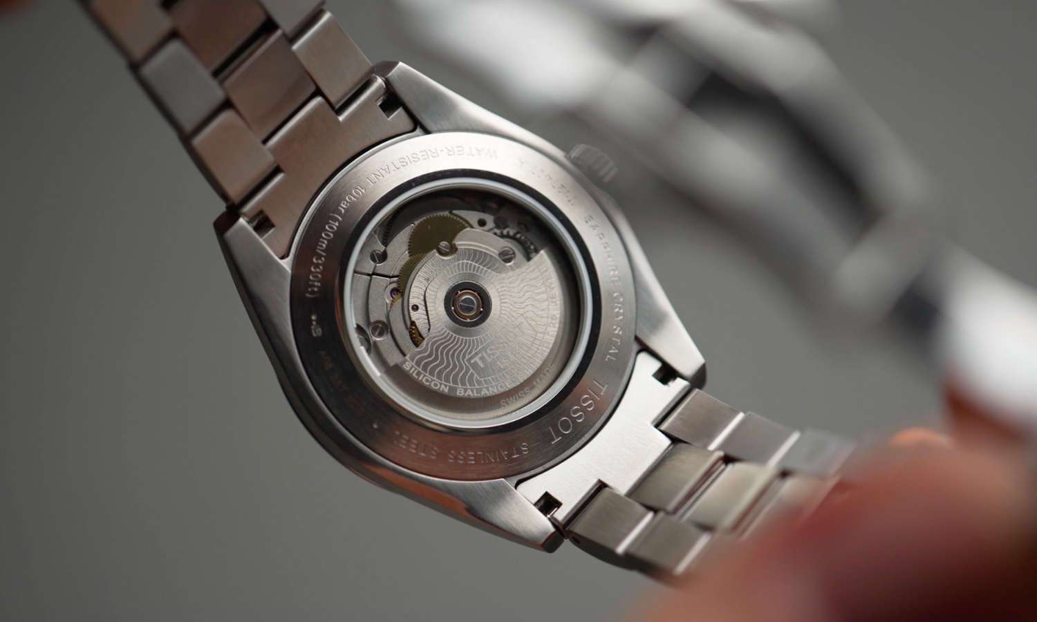 Das Powermatic 80 Automatikwerk der Tissot Gentleman Powermatic 80 vor grauem Hintergrund