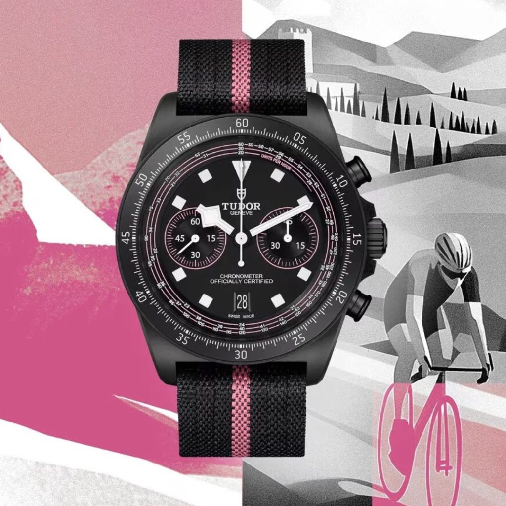 Blick von vorne auf den TUDOR Pelagos FXD Chrono "Pink". Im Hintergrund ist eine Zeichnung einer Landschaft beim Giro d'Italia.