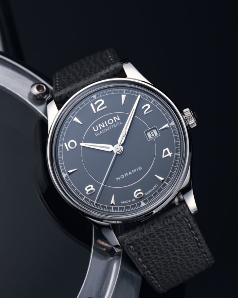 Union Glashütte Noramis Datum mit grauem Zifferblatt und grauem Lederarmband vor schwarzem Hintergrund