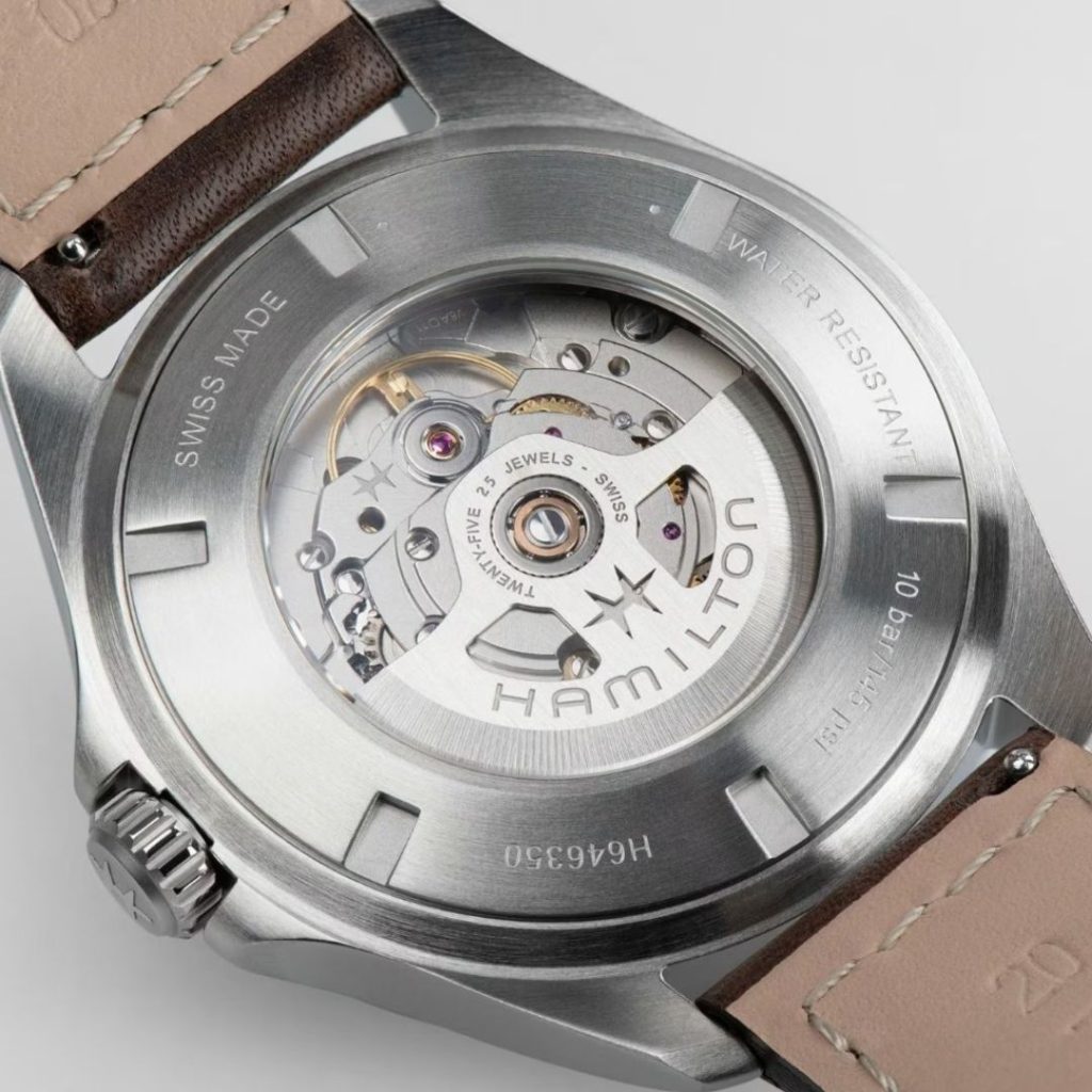 Nahaufnahme des offenen Gehäusebodens der Hamilton Khaki Aviation Pilot Day Date Auto vor weißem Hintergrund