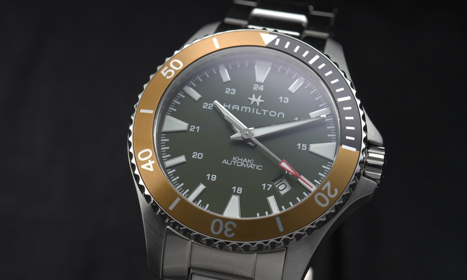 Nahaufnahme des grünen Zifferblatts der Hamilton Khaki Navy Scuba Auto Referenz: H82375161 vor schwarzem Hintergrund
