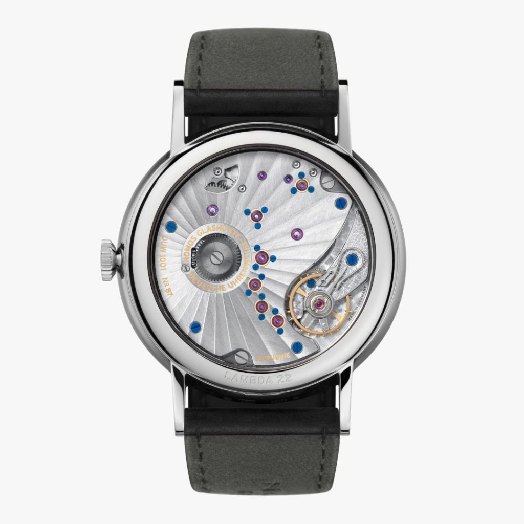 Nahaufnahme des offenen Gehäusebodens der NOMOS Glashütte Lambda Tiefblau mit Blick auf das schön verzierte Werk vor weißem Hintergrund
