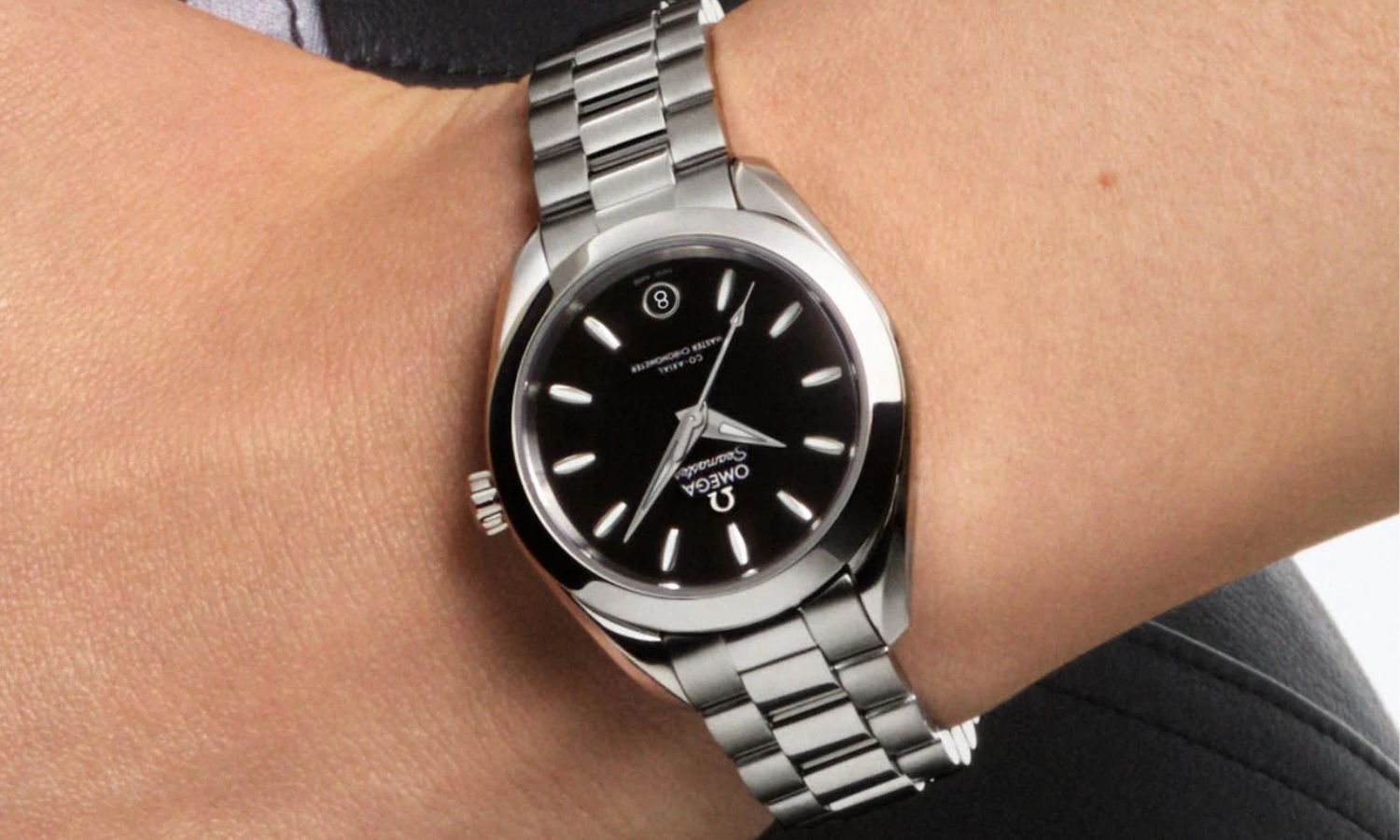 Blick auf die neue OMEGA Seamaster Aqua Terra 30 mm mit schwarzem Zifferblatt auf dem Handgelenk einer Frau.